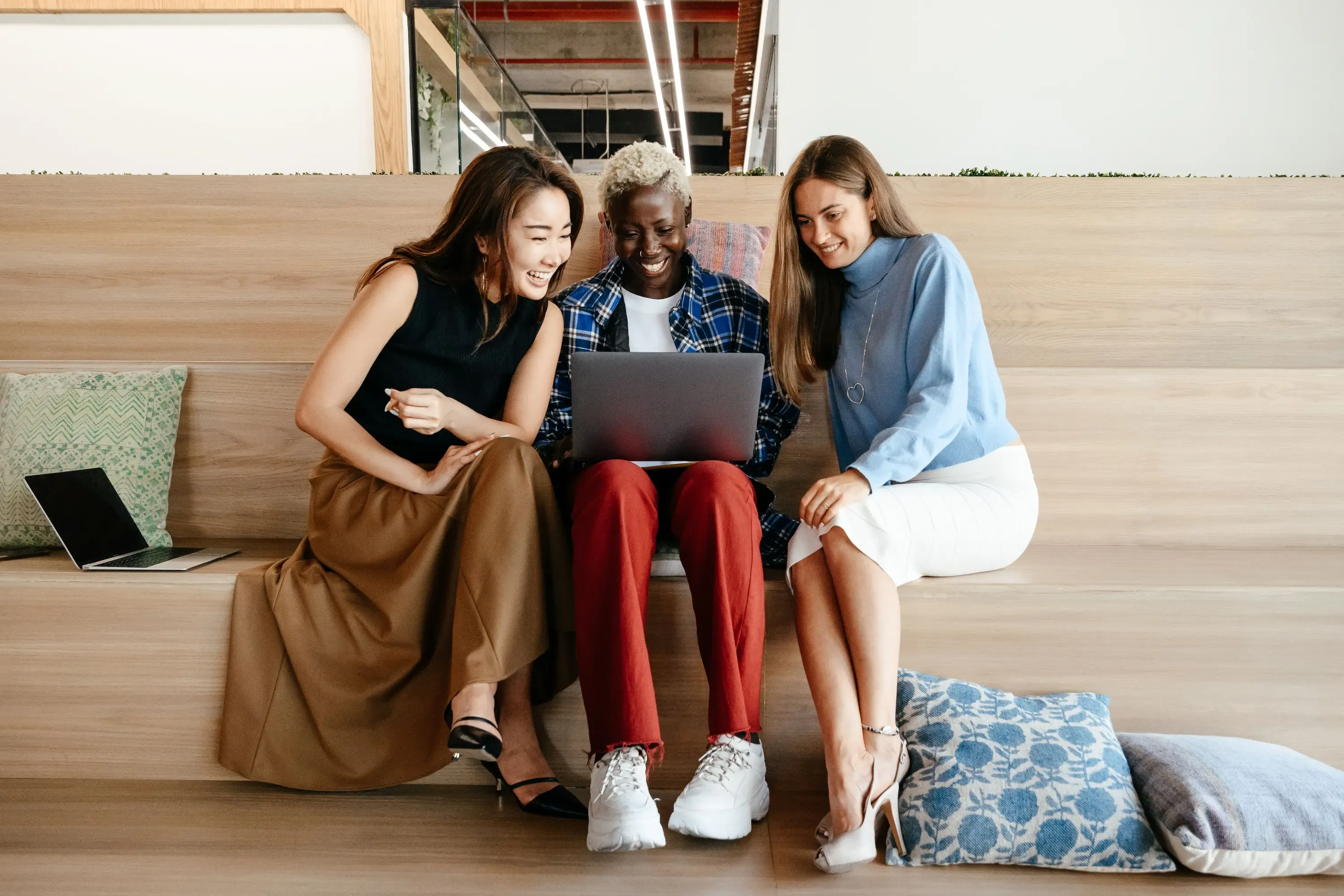 Three women sharing ideas around a laptop